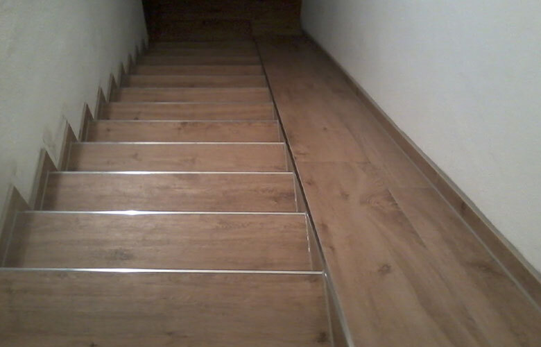 Geflieste Treppe mit Holzoptik-Fliesen und Edelstahlprofil – trittsichere Stufenlösung im Innenbereich